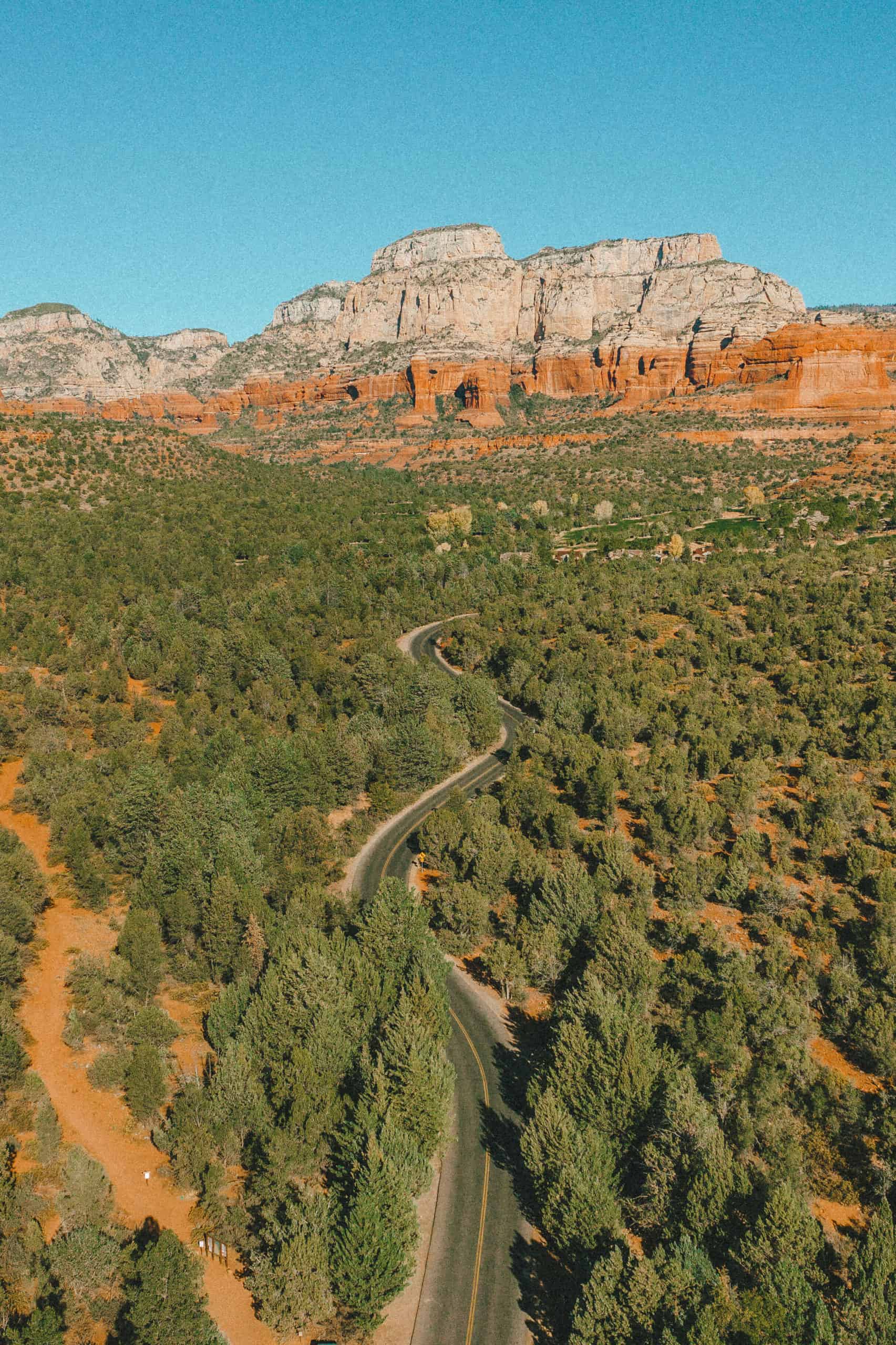 Red rock views and winding road in Sedona, Arizona from above (as seen by drone)