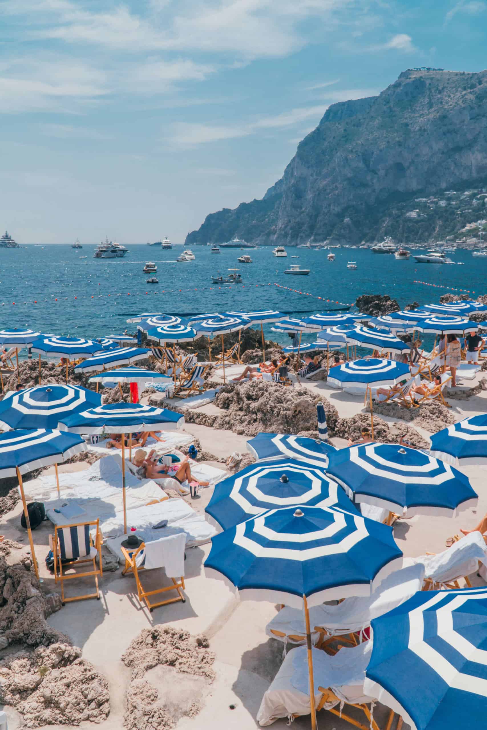 Blue and white umbrellas at La Fontelina Beach Club in Capri, Italy