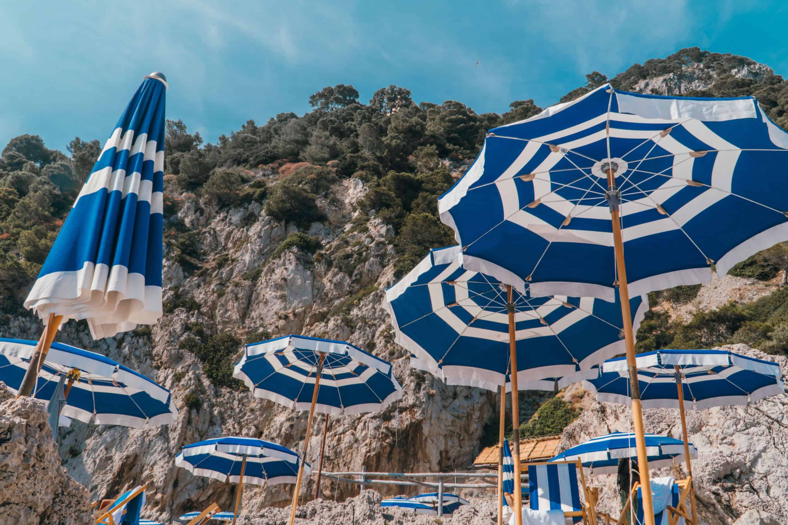 Blue and white umbrellas at La Fontelina Beach Club in Capri, Italy