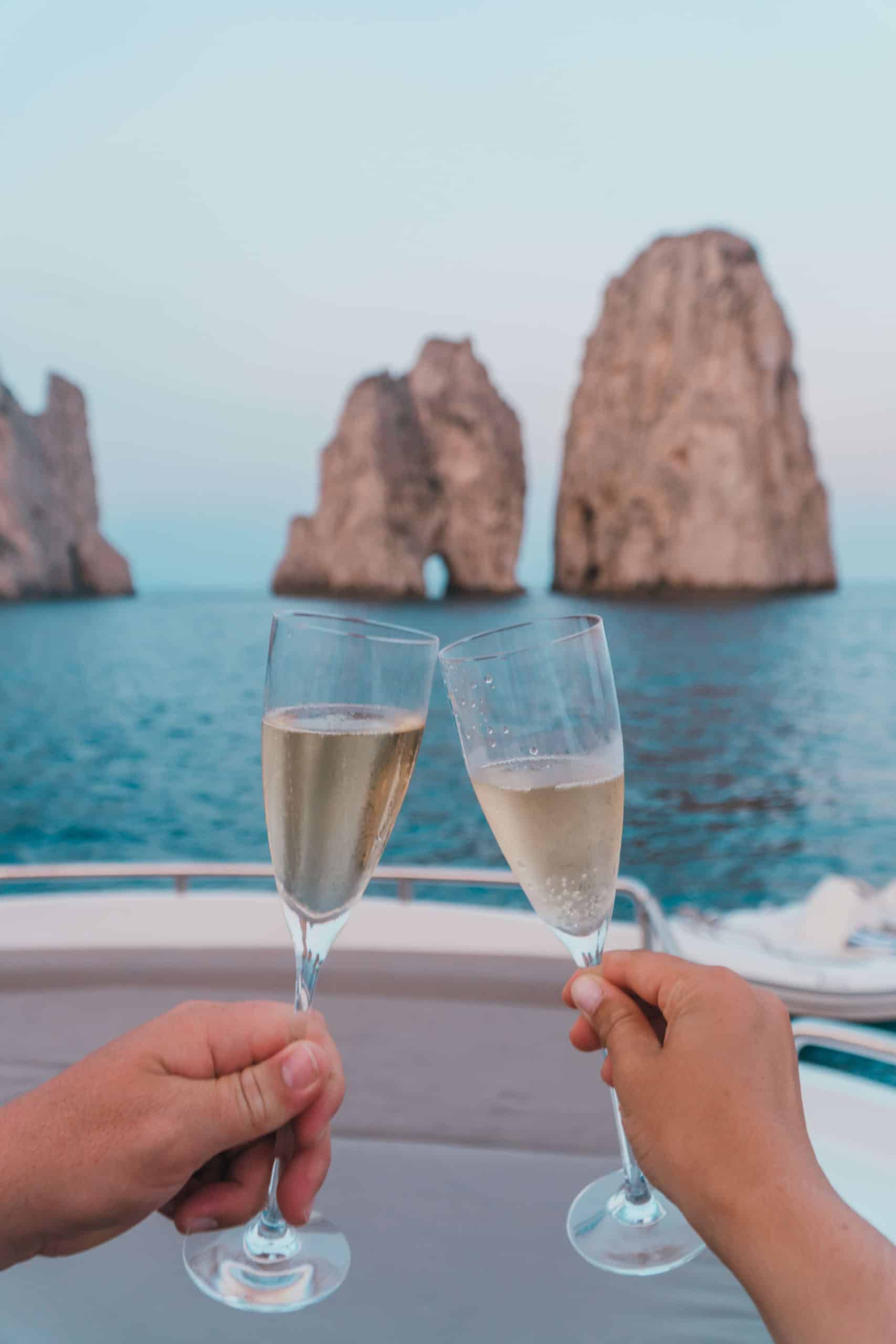 Toasting champagne in front of the Faraglioni in Capri, Italy