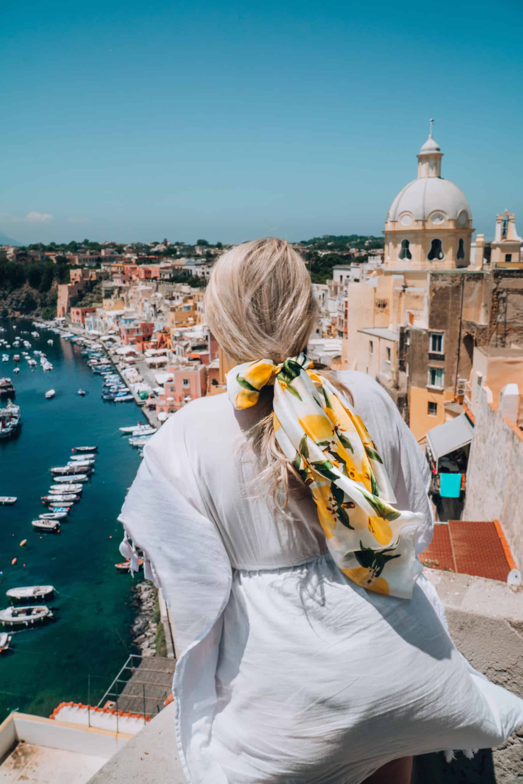 Wearing a lemon print scarf looking over the views of Procida, Italy