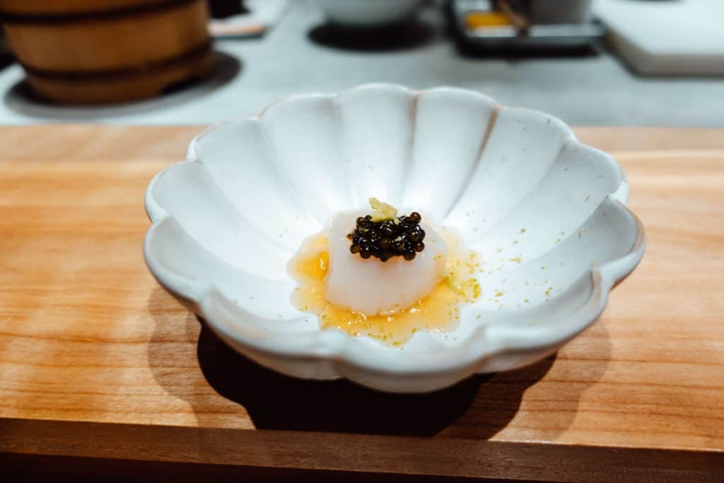 Scallop in yuzu sauce topped with lime zest and Kaluga caviar at Omakase by Gino