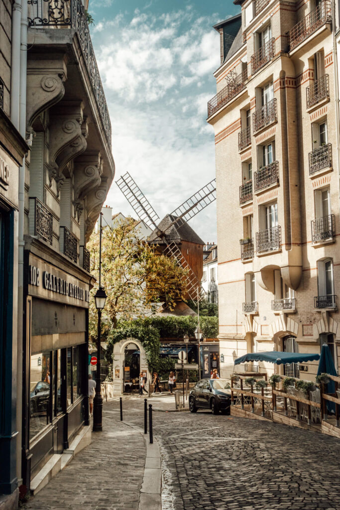 View of a windmill on a picturesque cobblestone street in Paris