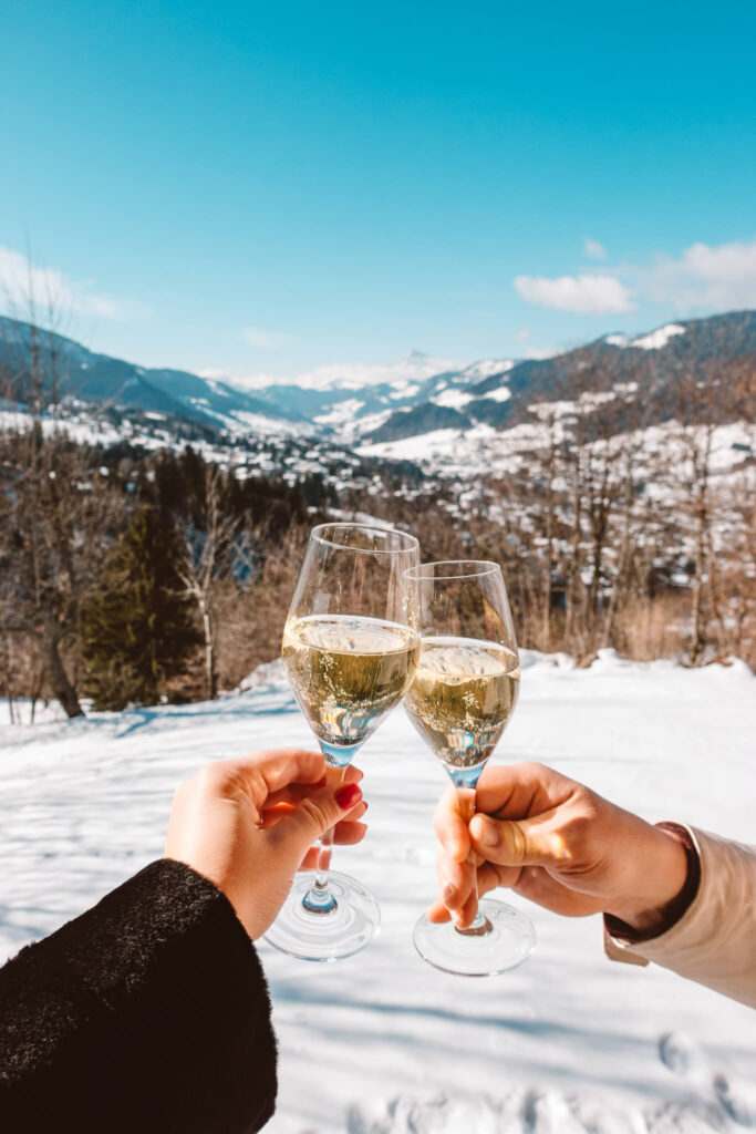Champagne cheers with the French Alps in the background from the balcony at Les Chalets du Mont d’Arbois