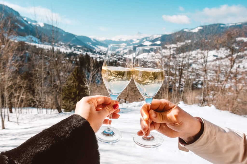 Champagne cheers with the French Alps in the background from the balcony at Les Chalets du Mont d’Arbois